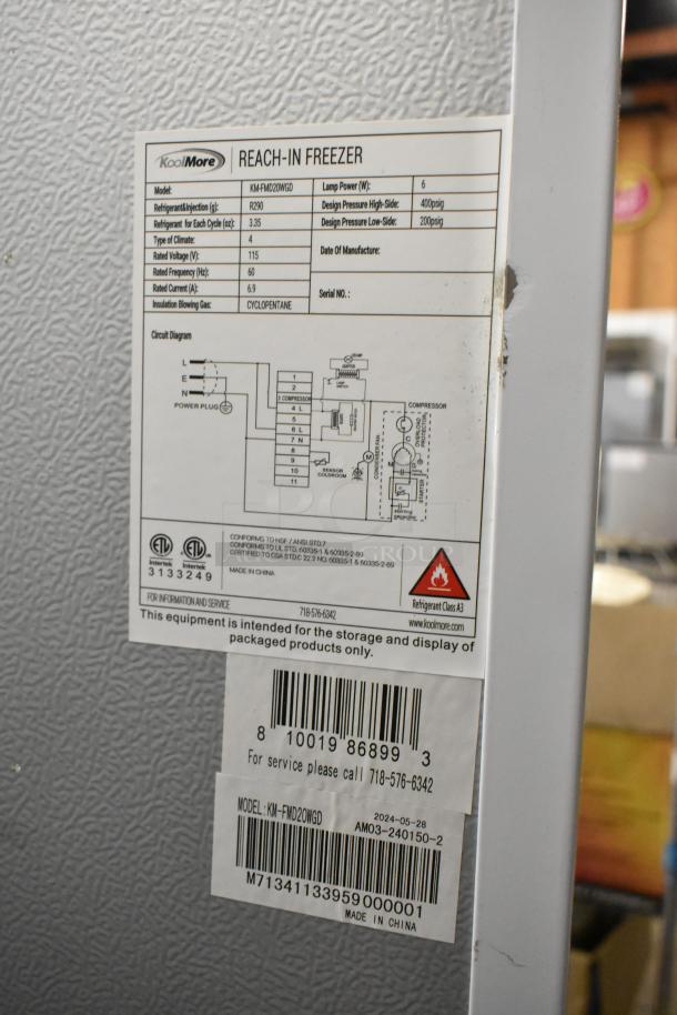 KoolMore KM-FMD20WGD commercial freezer label showing model, specs, and contact details; visible scratch on side.