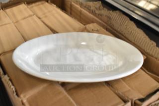 Box of Corona 700121 white oval platters, brand new with minor scratches and dents, on cardboard packaging.