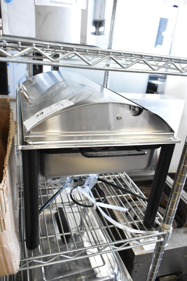 Stainless steel countertop chafer, brand new, visible minor scratches and dents, black handles, auction label attached.
