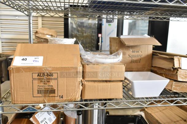 New scratch and dent boxes of Acopa 50 oz. square white melamine bowls, American Metalcraft 6 1/4" white round plates, Tuxton ALD-046 fruit bowls.