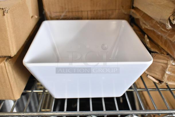 Brand new Acopa Rittenhouse 50 oz. square white melamine bowl displayed on a shelf with cardboard boxes.