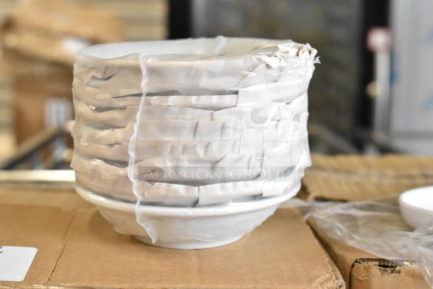 Stack of brand new white melamine bowls wrapped in protective padding, boxed and ready for auction.