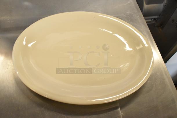 Brand new white ceramic plate on metal surface, part of a scratch and dent lot. Smooth finish, minor blemishes visible.