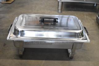 Brand new stainless steel chafer with minor scratches and dents, features a black handle and sturdy feet.