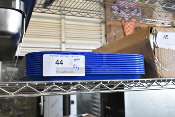 Alt text: "11 new Choice 999FT1418BL blue poly food trays, scratch and dent condition, on metal shelf with auction label."