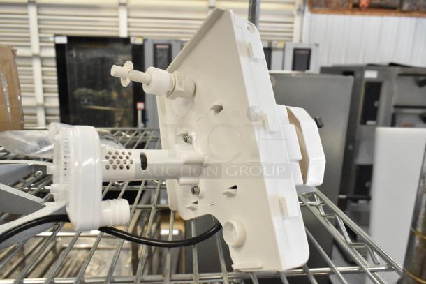 Brand new pump with minor scratches and dents, white plastic, mounted on metal rack, visible vents, and connecting ports.