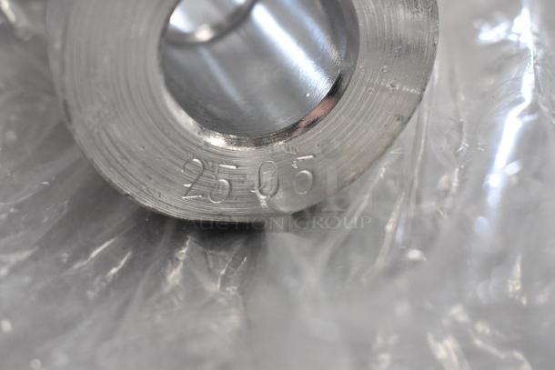 Close-up of a metal item with engraving "2505" visible, featuring a smooth, reflective surface. Item appears in excellent condition.