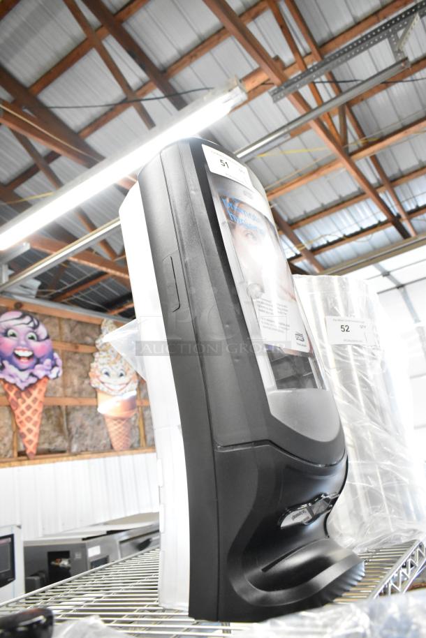 BRAND NEW Tork black and clear poly napkin dispenser with minor scratches. Features easy-access design. Tag visible.