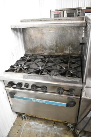 Radiance stainless steel 6-burner commercial gas range with oven, over shelf, backsplash, on casters. Used condition.