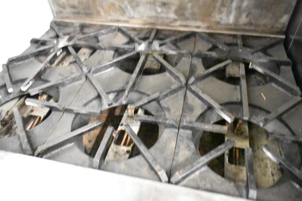 Radiance commercial gas range with 6 burners, oven, over shelf, and backsplash on casters; used condition.