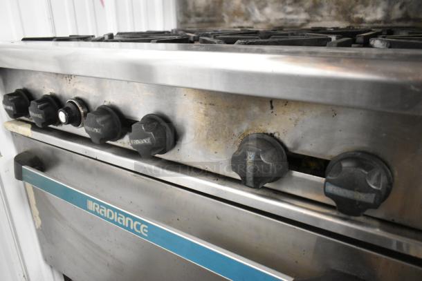 Radiance stainless steel commercial gas range with 6 burners, oven, over shelf, and backsplash on casters; used condition.