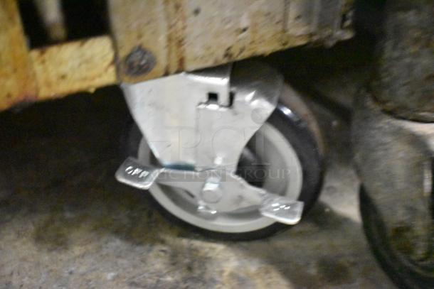 Radiance stainless steel caster with lock, part of a commercial 6 burner range, shows wear, ideal for maneuverability.