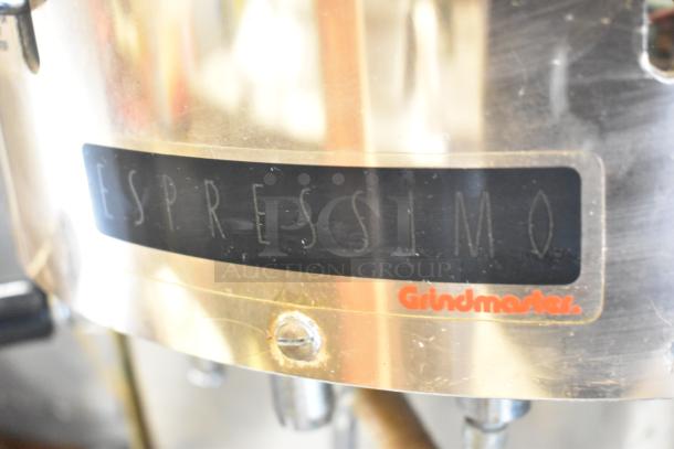 Grindmaster 2100Q Espressimo espresso machine, metal finish, featuring 2 portafilters, steam wand, "Espressimo" and "Grindmaster" logos.