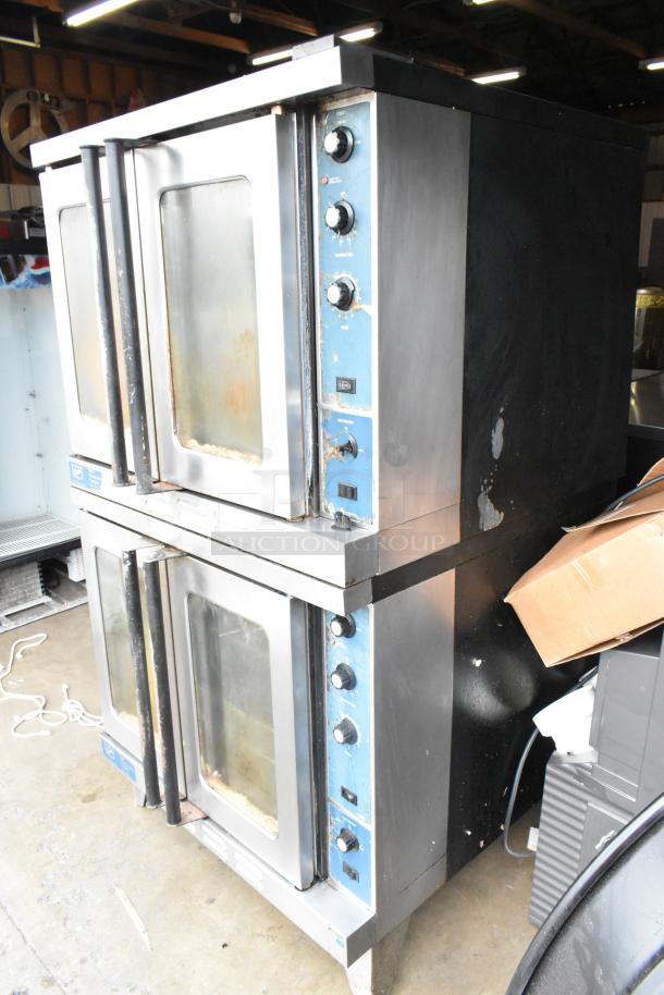 Two Duke stainless steel commercial gas convection ovens, full-size with view-through doors, metal racks, and thermostatic controls.