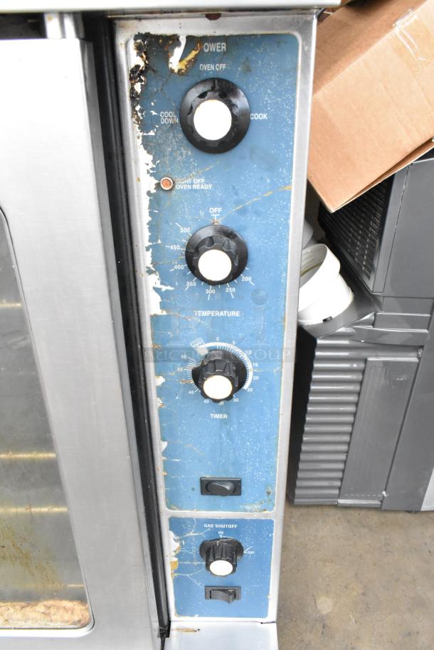 2 Duke gas convection ovens with view doors, metal racks, and thermostatic controls. Stainless steel, industrial use.