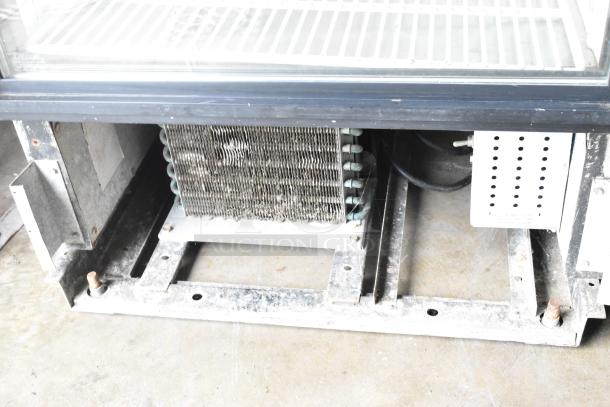 True GDM-12 metal commercial single door cooler's base and internal components, showing wear and rust. Model details not visible.