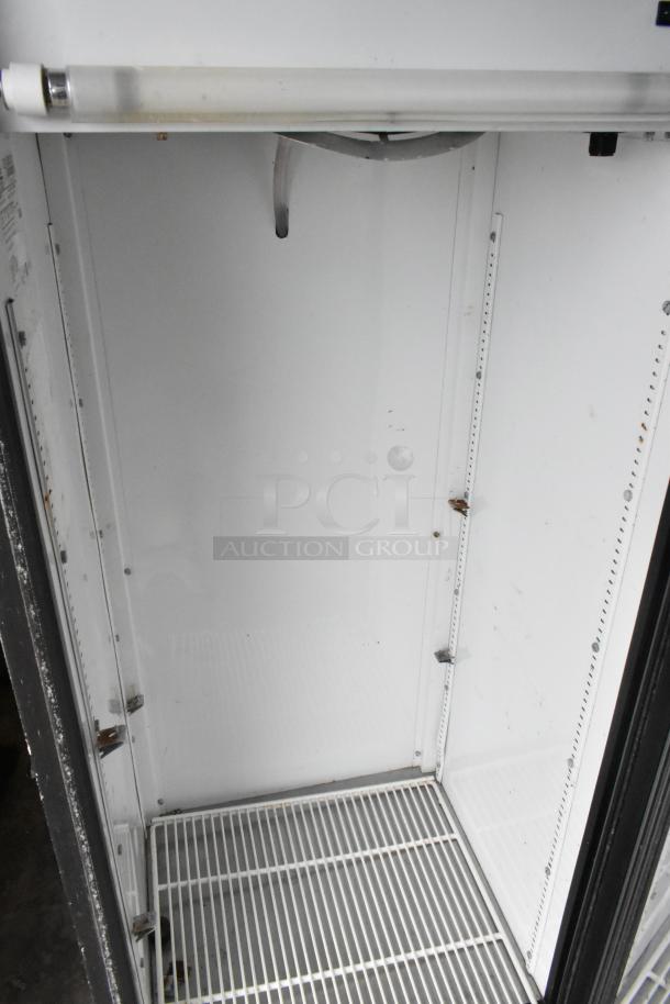 True GDM-12 commercial cooler interior. Metal shelves, single-door design. 115 volts, 1 phase. Some wear visible.