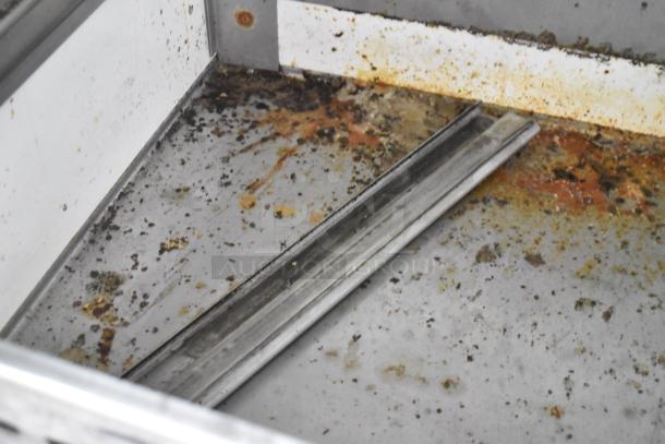 True TWT-93D-6 stainless steel undercounter cooler interior, showing signs of residue and rust. Model on commercial casters.