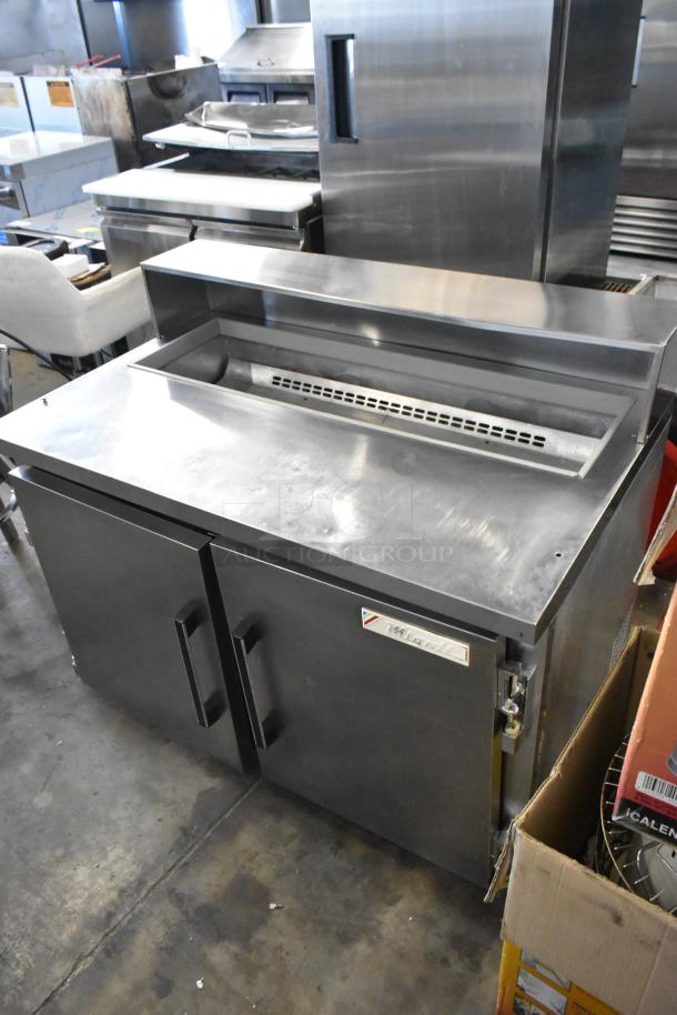 Migali CA-4-12 stainless steel commercial salad prep table; missing lid; dual doors; 115 volts, 1 phase.