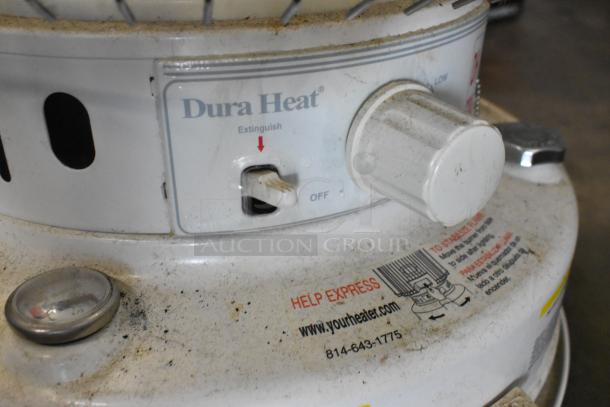 Close-up of a Dura Heat DH-D floor-style kerosene heater with visible control knob and help express label, showing signs of use.