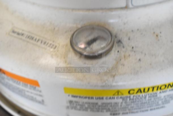 Close-up of a Dura Heat DH-D floor-style kerosene heater. Visible caution label and temperature gauge in used condition.