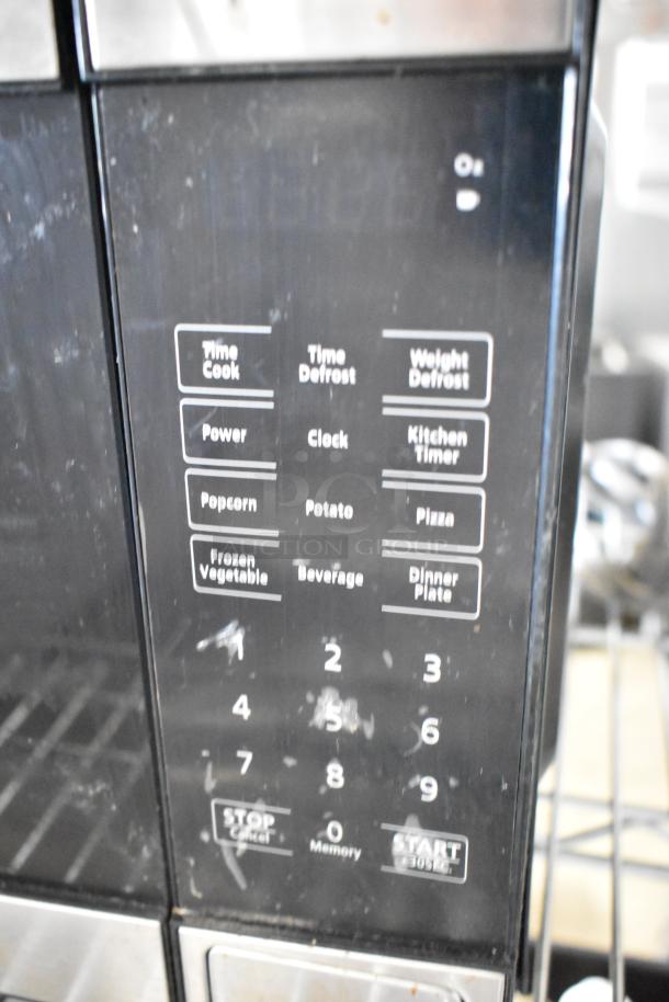 Walmart EM720C2WT-PM countertop microwave with keypad controls, 120 volts, 1 phase. Functions visible include defrost and timer.