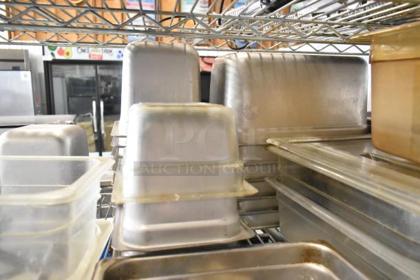 Tiered lot of kitchen items with poly and stainless steel drop-in bins on metal shelves. Mixed condition.
