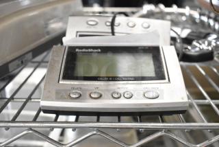 Two RadioShack Caller ID devices with LCD screens, buttons for delete, VIP, review, call back. Slightly worn condition.
