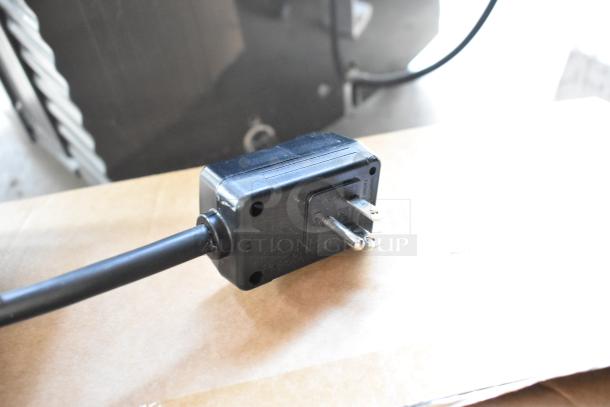 Power plug of Whynter ARC-14S portable air conditioner. Black, with visible prongs, part of new scratch and dent item.