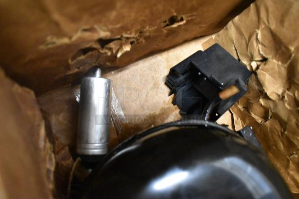 Brand new Avantco 17812362 compressor for specific unit series, 115V, R-290, shown in damaged packaging, minor visible wear.