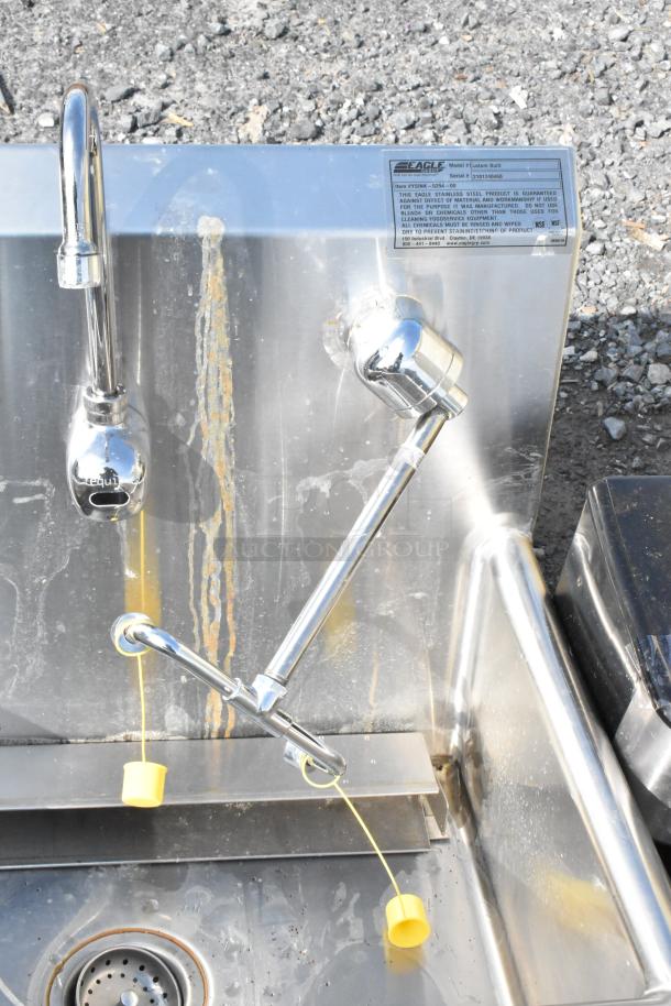 Eagle stainless steel single bay sink, no legs. Features dual faucets, visible wear, and rust stains. Model label present.