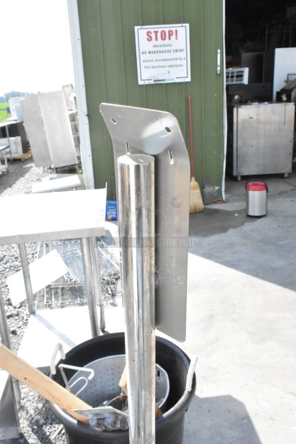 Stainless steel metal stand with mounting holes, in good condition, features a cylindrical pole and flat base.