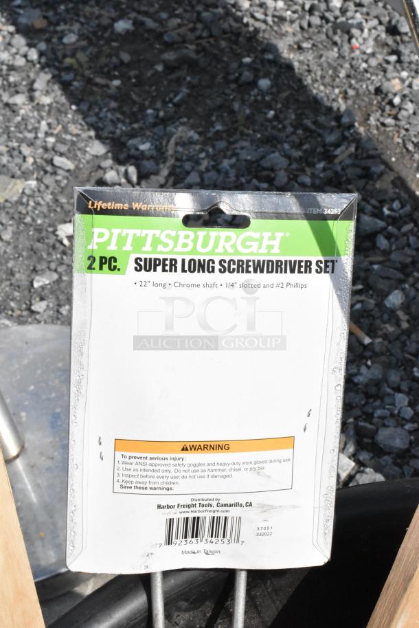 Black poly bin with contents, including a steam stock pot and Pittsburgh 2-piece super long screwdriver set, 22" chrome shaft.