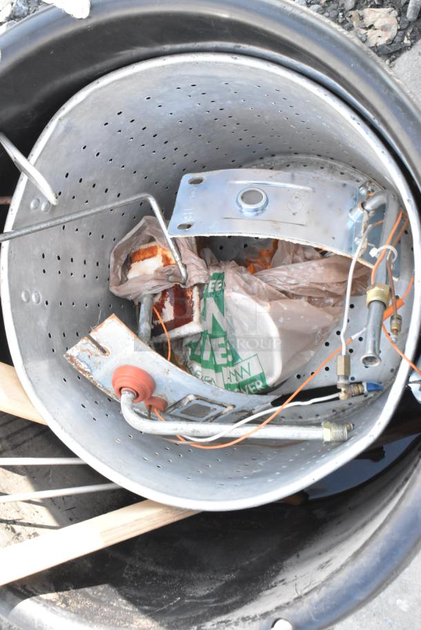 Black poly bin containing a large steam stock pot, metal parts, wires, and plastic bags. Slight rust on components.