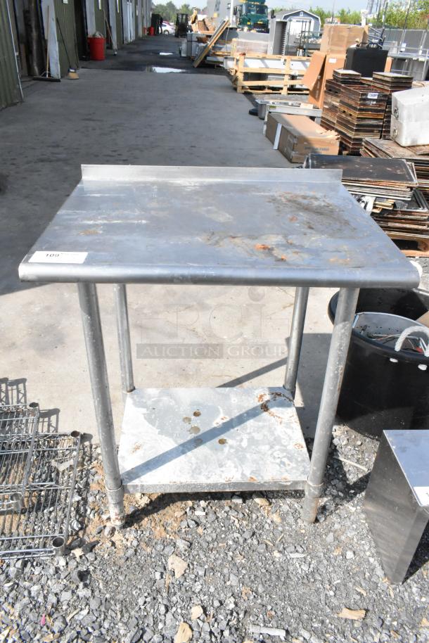 Stainless steel table with metal under shelf, visible wear, and rust marks, item tag "109" on surface, ideal for industrial use.