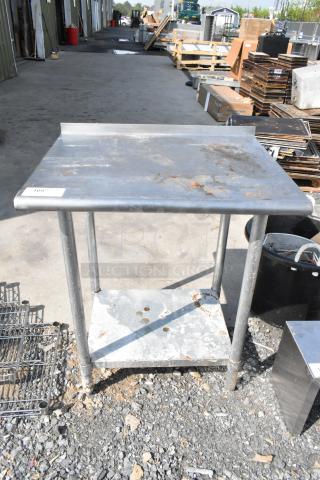 Stainless steel table with metal under shelf, visible wear, and rust marks, item tag "109" on surface, ideal for industrial use.