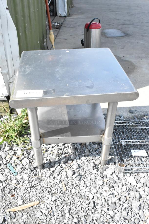 Stainless steel commercial equipment stand with metal under shelf, used condition, item tag 111 visible on top.