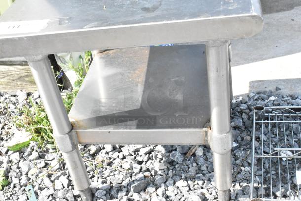 Stainless steel commercial equipment stand with metal under shelf, minor surface wear, sturdy construction, ideal for kitchen use.