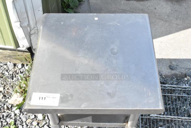 Stainless steel commercial equipment stand with metal under shelf, minor surface wear, auction tag visible.
