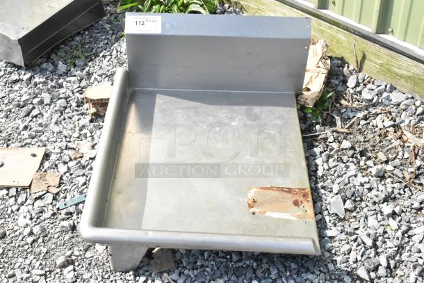 Stainless steel left side clean dishwasher table, no legs. Features backsplash and drainage area. Visible wear and rust on edge.