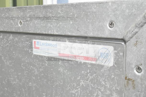 Lockwood metal commercial enclosed pan rack with visible wear. Label indicates Lockwood make and model CA60-RP23. Door does not stay closed.