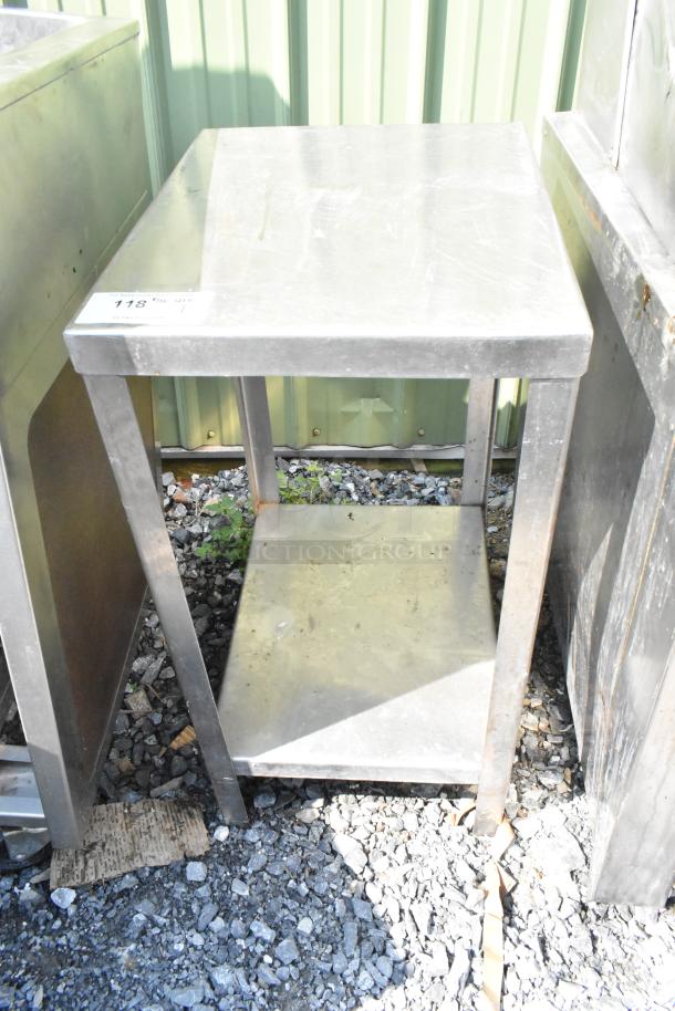 Metal table with under shelf, used condition. Visible wear on surface. Tag reads "118 Qty 1." Ideal for storage or workspace.