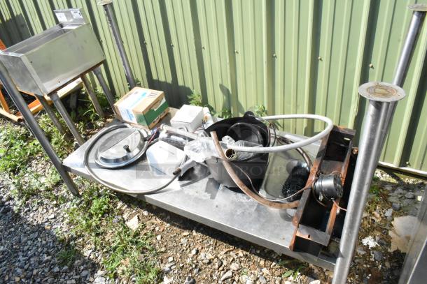 Metal under shelf with legs, includes mixed contents such as hoses, a pot, and boxes. Used condition.