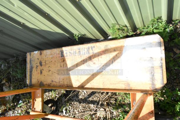 Metal cart with commercial casters, weathered surface, visible industrial markings, sturdy frame. Outdoor placement.