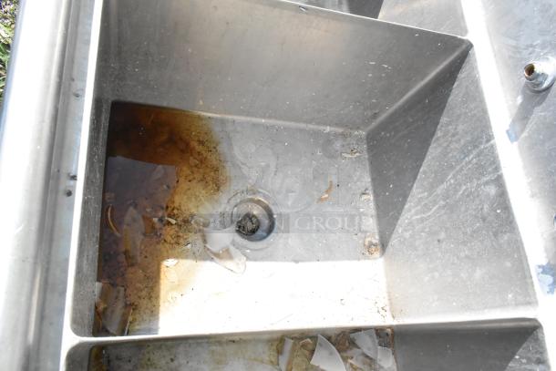 Marlo stainless steel 3 bay sink with dual drain boards, visible wear, and residue in the basin. Ideal for commercial use.