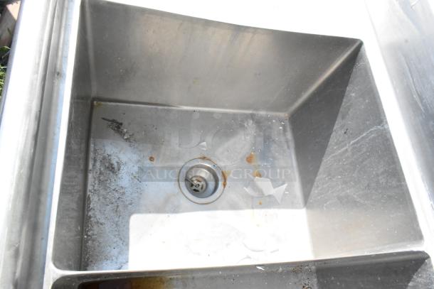 Marlo Stainless Steel 3 Bay Sink with dual drain boards, showing one bay's interior. Appears used with visible debris.