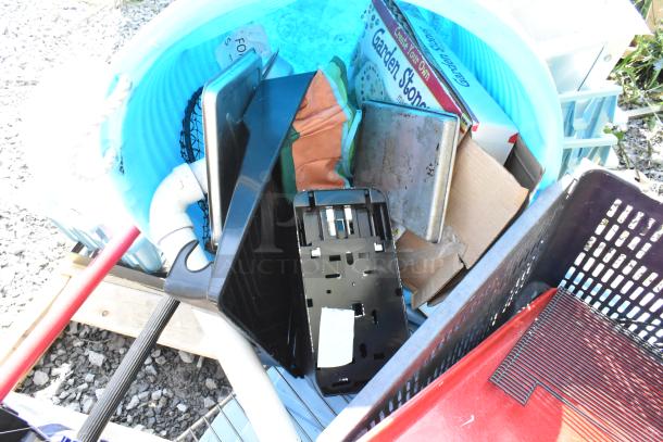 Pallet with assorted items: snow shovels, poly bucket, metal shelf, garden stone kit, and miscellaneous components.