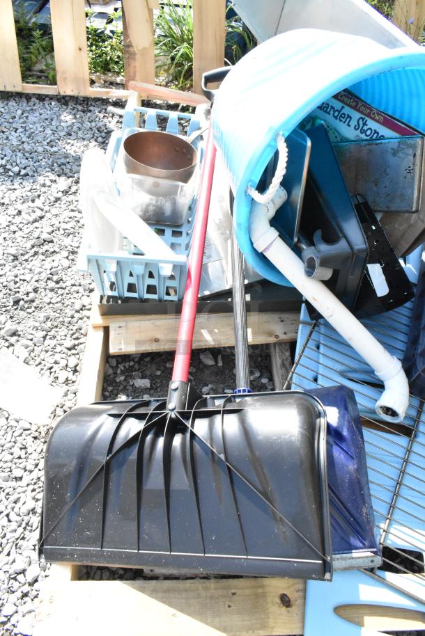 Pallet lot with black snow shovels, blue poly bucket, metal shelf, and assorted items, mixed condition.