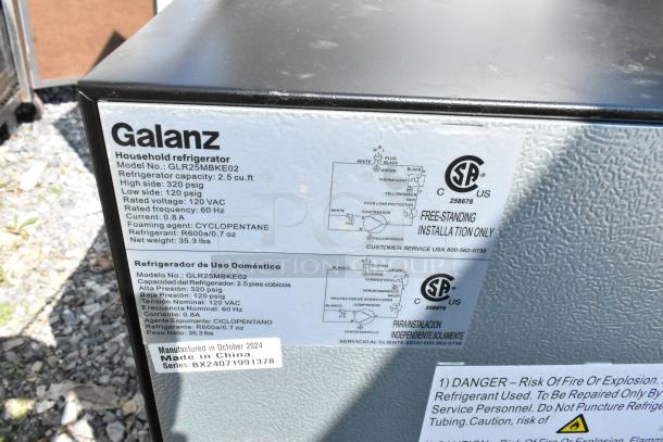 Alt text: Galanz GLR25MBKE02 mini cooler label showing 2.5 cu. ft capacity, 120 VAC, manufactured in China, model details.