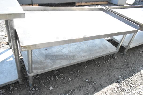 Regency stainless steel equipment stand with metal under shelf, showing wear and outdoor exposure.